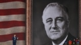 Президент США Дональд Трамп выступает на церемонии по случаю 75-й годовщины высадки союзных войск в Нормандии 5 июня 2019 года на фоне флага США и портрета президента времен Второй мировой Франклина Д. Рузвельта