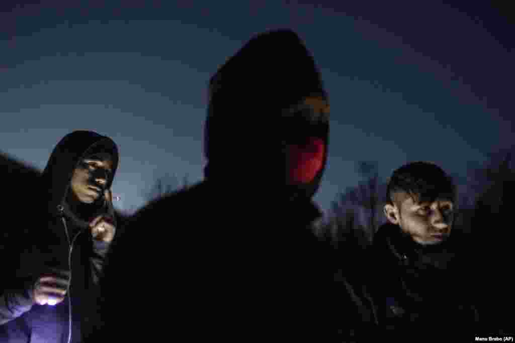 Migrantët afganë qëndrojnë pranë një fermë të braktisur në anën boshnjake të maleve afër kufirit me Kroacinë. 