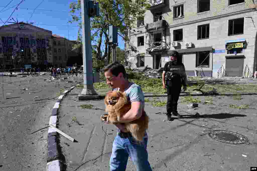 Житель забирает собаку из разрушенного жилого дома 