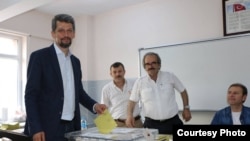 Turkey - Garo Paylan (L), an ethnic Armenian candidate of the People's Democratic Party (HDP), casts a ballot at a polling station in Istanbul, 7Jun2015.