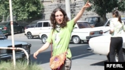 Armenia -- Mariam Sukhudian, a civic activist charged with "false deninciation," greets supporters as she heads to a police station in Yerevan for interrogation on August 19, 2009.