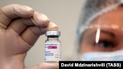 GEORGIA -- A health worker holds a vial containing the AstraZeneca vaccine against COVID-19 used at the Infectious Diseases, AIFS and Clinical Immunology Research Center in Tbilisi, March 15, 2021