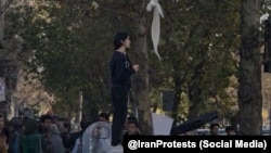 تصویر زنی که در اقدامی صلح‌آمیز در خیابان انقلاب به حجاب اجباری اعتراض کرد و سپس دستگیر شد