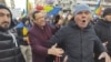 Un bărbat încearcă să liniștească un manifestant care huiduie o echipă de jurnaliști la protestul AUR, pe 12 ianuarie 2025.
