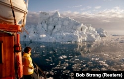 Турист, любующийся ледяным морским пейзажем залива Disko Bay, Гренландия, май 2007 года