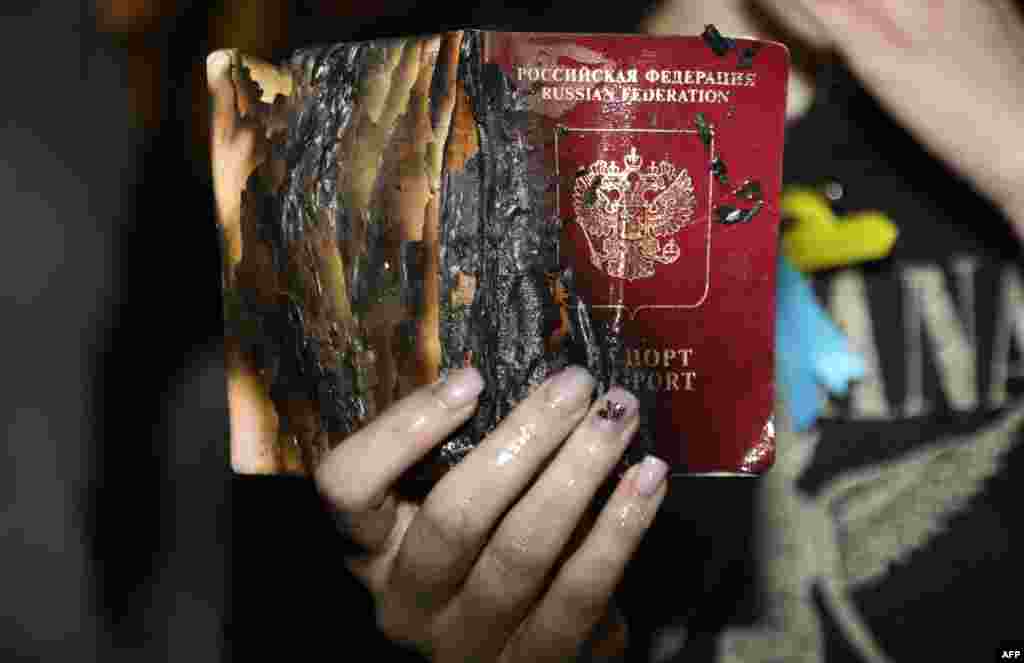 Каршылык акциясына чыккан жаран Орусиянын паспортун өрттөдү. Орусиянын Израилдин Тел-Авив шаарындагы элчилигинин алдындагы митинг.
