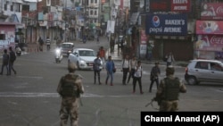 Indian paramilitary soldiers stand guard during a curfew like restrictions in Jammu on August 5.