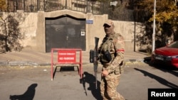 A fighter walks outside the Turkish Embassy after fighters of the ruling Syrian body ousted Syria's Bashar al-Assad, in Damascus on December 14.
