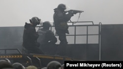 Вооружённый полицейский за ограждением. Алматы, 5 января 2022 года