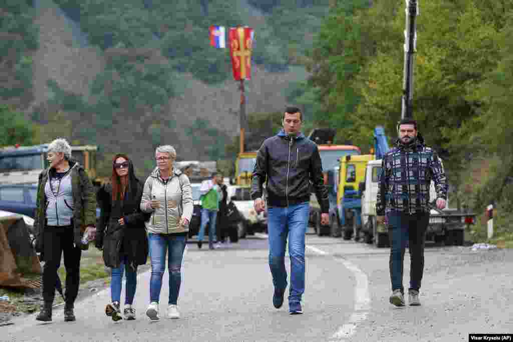 Etnici sârbi trec prin baricadele ridicate lângă punctul de trecere a frontierei din nordul Kosovo cu Jarinje, în a noua zi de proteste, 28 septembrie 2021. Sârbii din Kosovo au blocat granița pentru a noua zi consecutiv în semn de protest față de decizia autorităților kosovare, născând astfel temerea că astfel de incidente ar putea declanșa tensiuni mult mai profunde între cei doi inamici din Balcani.