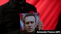 Portuqaliya, bir nümayişçi Belarus Mədəniyyət Evinin siyasi məhbuslara azadlıq tələbi ilə keçirdiyi aksiyada Aleksey Navalnının şəklini tutub, 6 mart 2021