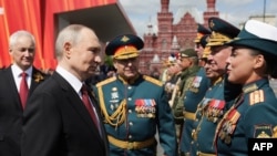 Prezident Vladimir Putin Moskvada Qələbə günü paradından sonra hərbi rəhbərləri salamlayır.