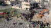 Excavatoarele sapă printre dărâmăturile unei clădiri distruse de bombardamentele israeliene la Rafah. 19 decembrie 2023.