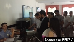 Айнур Ашим, дочь активистки Ардак Ашим, депутат парламента Италии Роберто Рампи (в центре) в фойе здания Южно-Казахстанского областного суда. Шымкент, 19 июня 2018 года.