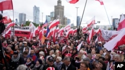 Un miting anti-imigrație la Varșovia, pe 10 mai, la care se pot vedea steaguri poloneze și americane, dar nu și drapelul UE.