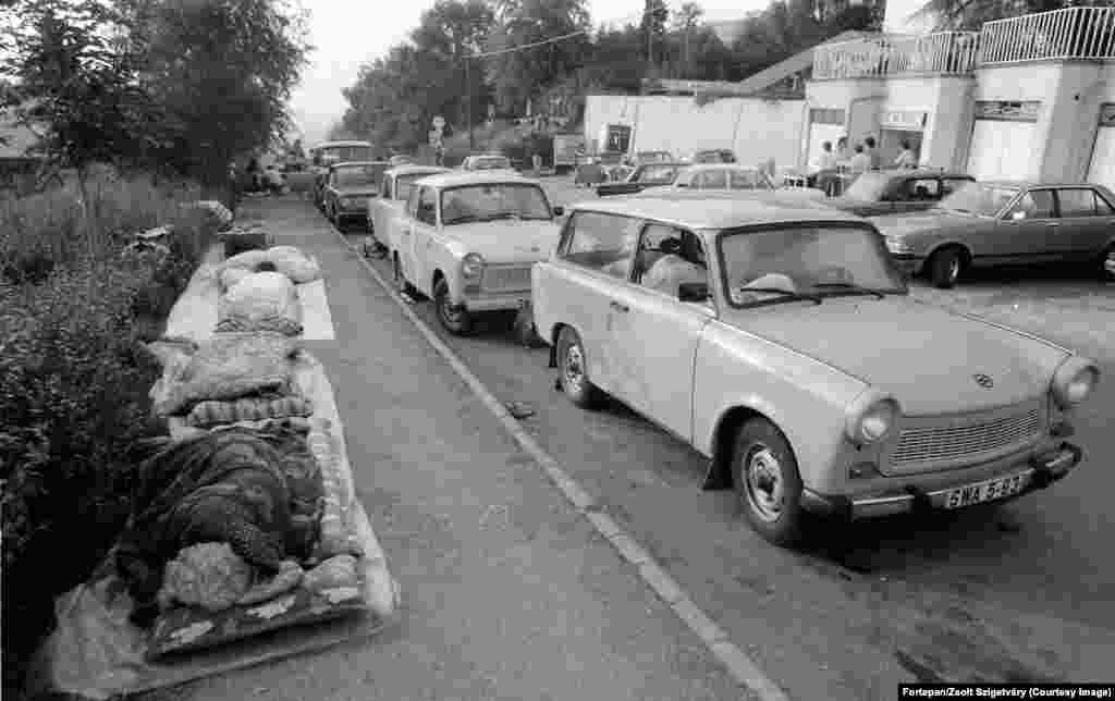 آوارگان آلمان شرقی در کنار خودروهای ترابانت‌شان در خیابان‌های بوداپست خوابیده‌اند. به‌دنبال تغییر سریع وضعیت مجارستان به سوی آزادی در سال ۱۹۸۹، هزاران تن از شهروندان آلمان شرقی که دائم تحت نظر و فشار پلیس مخفی یا اشتازی بودند، با خودروهای خود راهی شرق شدند. مجارستان یکی از کشورهای «سوسیالیست و برادر» محسوب می‌شد و شهروندان آلمان شرقی مجاز بودند به آن‌جا سفر کنند.