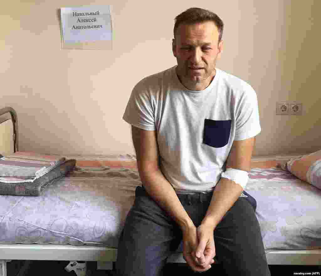 Një Navalny i sëmurë, me sytë e skuqur dhe të fryrë, qëndron ulur në një shtrat spitali në Moskë më 29 korrik 2019, ndërsa po vuante një dënim 30-ditor burgimi me akuzën e thirrjes së një proteste të paautorizuar. Ai tha se besonte se ishte helmuar, por mjekët ia atribuuan sëmundjen e tij një "reaksioni akut alergjik".