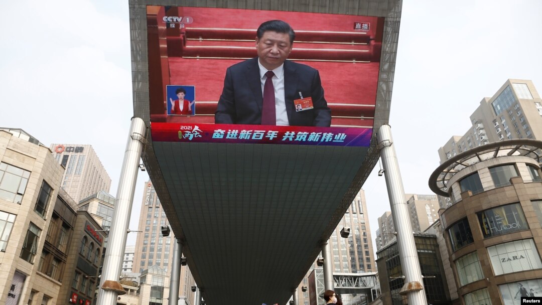 A giant outdoor screen shows Chinese President Xi Jinping attending the closing session of the National People's Congress in Beijing on March 11.