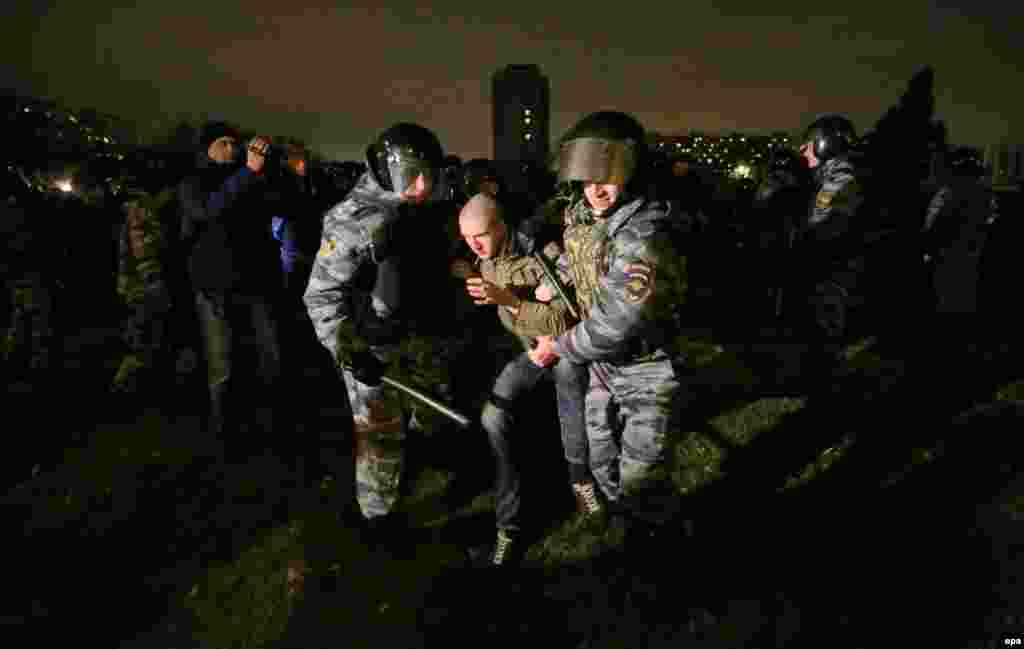 Ресей полицейлері 2013 жылы қазанда Мәскеудің Бирюлево ауданында мигранттарға қарсы тәртіпсіздіктер кезінде ұсталған адамды алып барады. Жергілікті жас орыс жігітін әзербайжандық мигрант жұмысшы пышақтап өлтіріпті-міс деген хабар ірі қақтығысқа ұласып, ұлтшылдар көліктерді қиратып, терезелерді сындырып, мигранттарды іздеп, көкөніс қоймаларын ақтарып тастады.