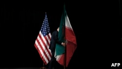 پرچم جمهوری اسلامی ایران (راست) و پرچم ایالات متحده آمریکا؛ عکس آرشیوی است