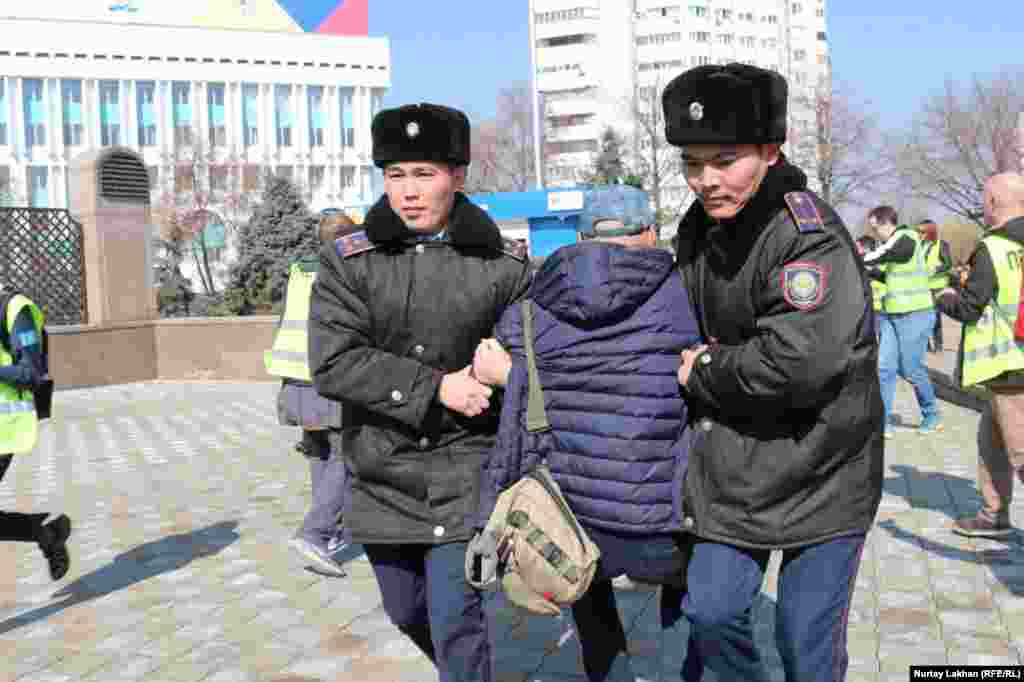 Полицейские тащат пришедшего к площади Республики человека. Накануне акций генеральная прокуратура Казахстана предостерегла казахстанцев от участия в том, что она назвала «незаконными акциями протеста», напомнив об административной ответственности за не согласованные с властями собрания. 