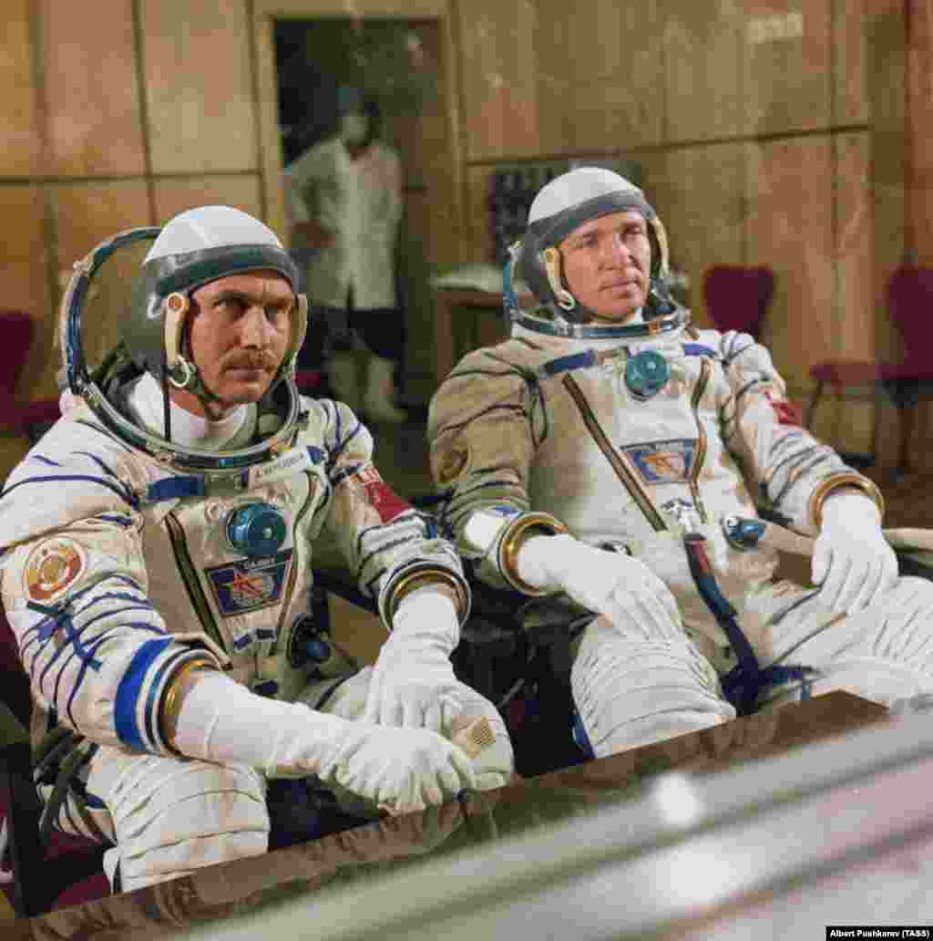 Космонавты Анатолий Березовой и Валентин Лебедев беседуют с журналистами, находясь за стеклянной перегородкой перед отправкой в космос в 1982 году. Несколько советских предстартовых традиций сохранились и по сей день. Так, космонавты перед полетом ходят на показ снятого в 1970 году фильма «Белое солнце пустыни» и мочатся на заднее колесо автобуса, который отвозит их к стартовой площадке. Сообщается, что женщины-космонавты приносят с собой небольшой сосуд с мочой для совершения ритуала. 